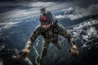 Man parachuting out of an airplane with snowcapped mountains in background