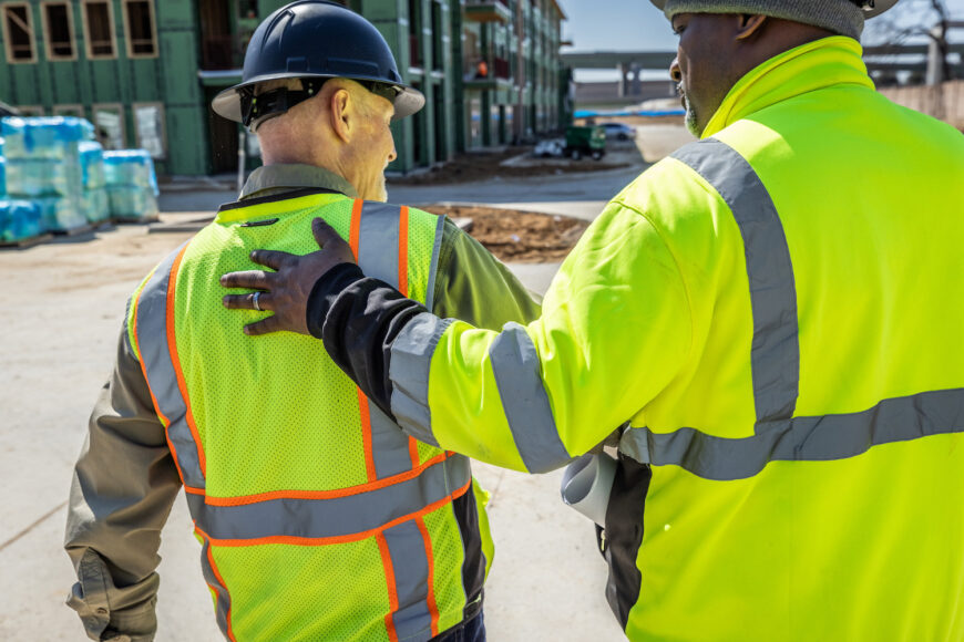 Two Construction workers walking next to one another