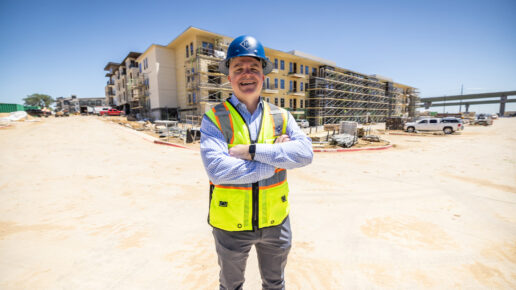 Construction worker with arms crossed looks into the camera