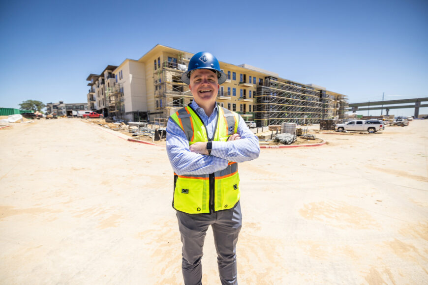 Construction worker with arms crossed looks into the camera